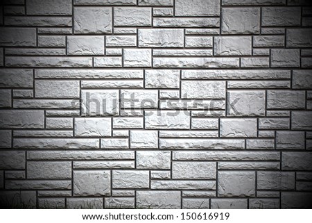 Weathered texture of stained old dark brick wall background, grungy rusty blocks of stone-work technology, colorful horizontal architecture