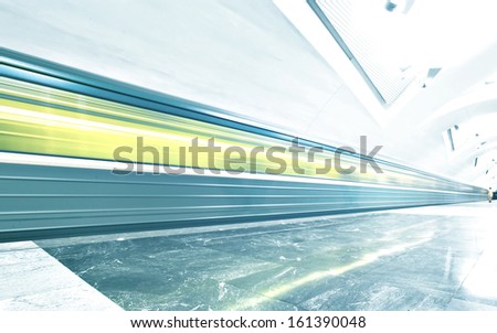 Perspective Wide Angle View Of Modern Light Blue Illuminated And Spacious Public Metro Marble Station With Fast Blurred Trail Of Vivid Yellow Train In Vanishing Traffic Motion