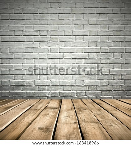 Grungy textured white brick and light gray stone wall with warm brown wooden floor inside old neglected and deserted darken room interior, masonry and carpentry brickwork concept