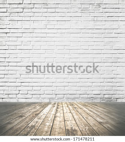 Grungy textured white brick and stone wall with warm brown wooden floor inside old neglected and deserted interior, masonry and carpentry brickwork concept
