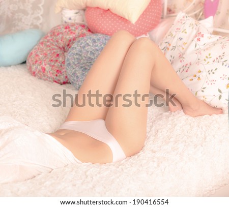 Portrait of beauty attractive fashion slim healthy young woman with perfect training sexy tanned skin sport body in an ideal white lingerie with curve torso and erotic thin waist isolated lying on bed