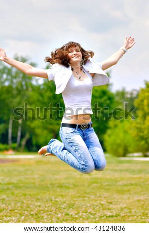 smile teen open hands jumping in green summer park