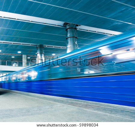 blue underground platform with moving train