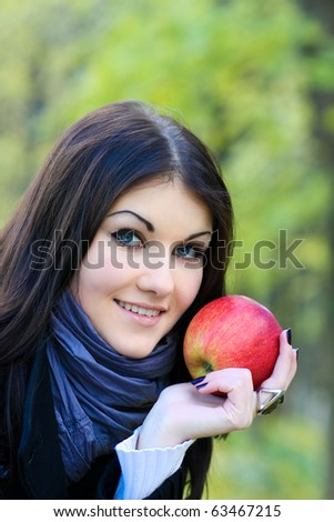 portrait of the beauty girl with red color apple in park