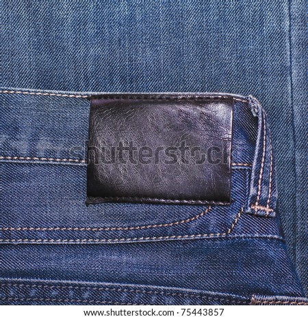Black leather label isolated over denim texture