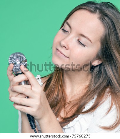 portrait of beautiful singer girl with microphone in hand