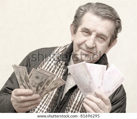 elderly happy man with pack of money