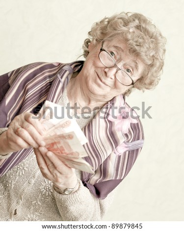 elderly happy woman with pack of money