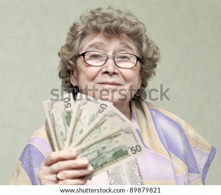 elderly happy woman with pack of money