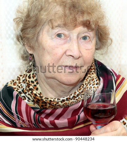 elegant senior lady holding a glass of red wine on a toast