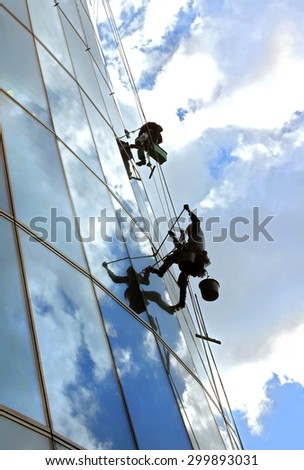 Glass wall cleaning. Workers washing windows in the office building