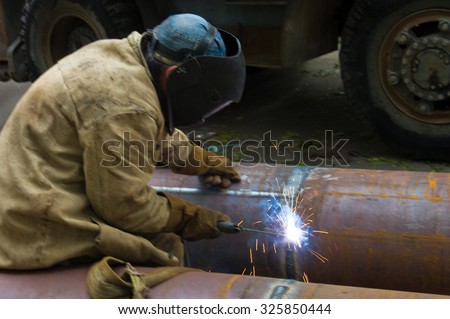 ODESSA, UKRAINE - 09 October 2015: Welder welds pipe segments. Repair and replacement of outdated pipes in the city center.
