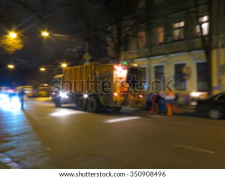 Abstract blurred Worker of municipal recycling garbage collector truck loading waste and trash bin. Night Scene. Great background