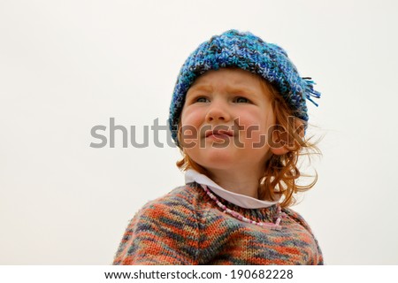head and shoulders of little red headed girl with hand knitted jersey and hat