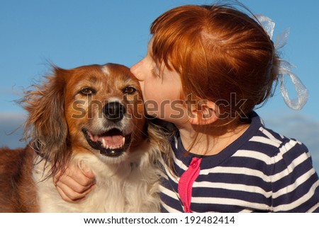 Red headed little girl hugging her red haired pet dog