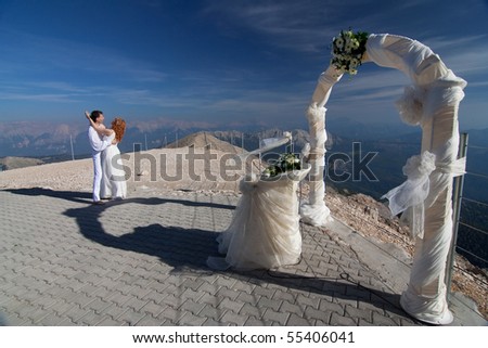 stock photo The newlyweds hugs near the wedding arch and altar against the