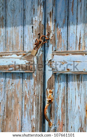 Detail of old blue shabby door of the abandoned house in Greece