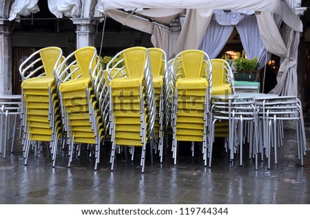 Stack of chairs and tables in front of the restaurant during low season in St.Mark\'??s Square in Venice