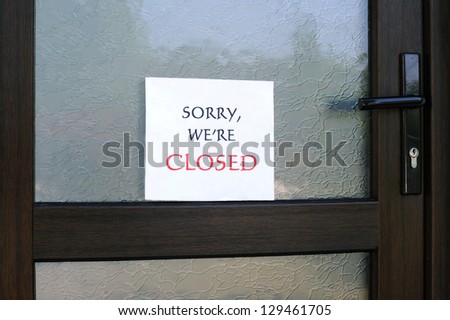 SORRY, WE\'RE CLOSED sign on the front door of a little store