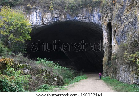 Woman walks out of Devetashka cave in Bulgaria in the fall