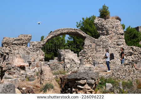GREECE, KOS - OCTOBER 03, 2014: Two men and their radio-controlled drone above the ancient ruins in Kos island