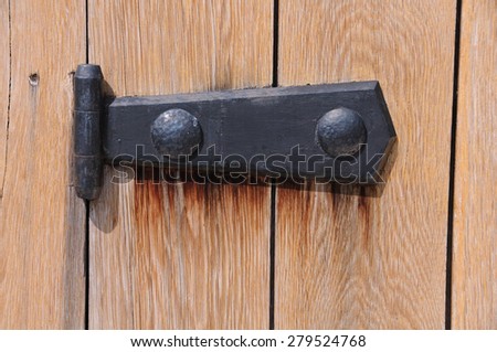Black medieval door hinge on the wooden gate in Bulgaria
