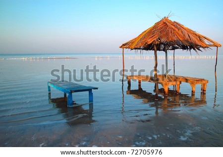 stock-photo-sun-umbrella-and-sun-lounge-on-the-flooded-beach-in-the-indian-state-of-goa-72705976.jpg