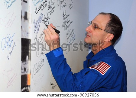 BAIKONUR, KAZAKHSTAN - DECEMBER 16: Expedition 31 US crewmember Don Petit signs a poster of Soyuz launch at the Korolev Museum on December 16, 2011 at the Baikonur cosmodrome in Baikonur, Kazakhstan