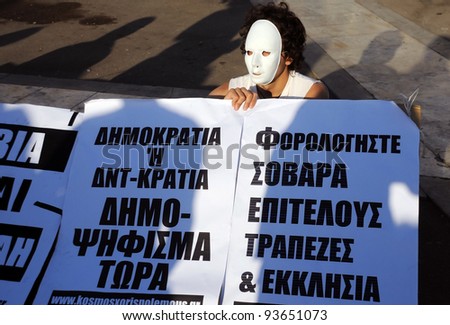 ATHENS, GREECE - MAY 9: Young man in white mask is protesting in the capital of  Greece Athens outside the Parliament building against unpopular EU-IMF austerity deal May 9, 2010 in Athens, Greece