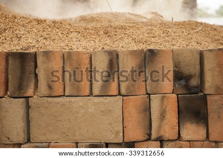 Brick factory. Baking bricks with sawdust on fire. Slow combustion. Bali, Indonesia