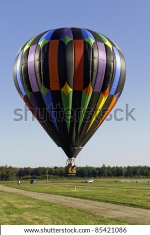 X Marks the Spot.  Colorful hot air balloon dips low to ground to drop beanbag directly on target.