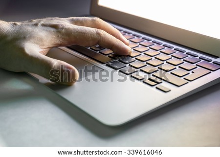 Human hand working with laptop computer