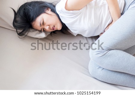 Asian woman having painful stomachache,Female suffering from abdominal pain,Period cramps