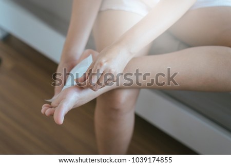 Woman using  white patch for relieve pain and relax on foot sole,Injury feet