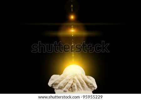 Spiritual healing light in cupped hands on a black background