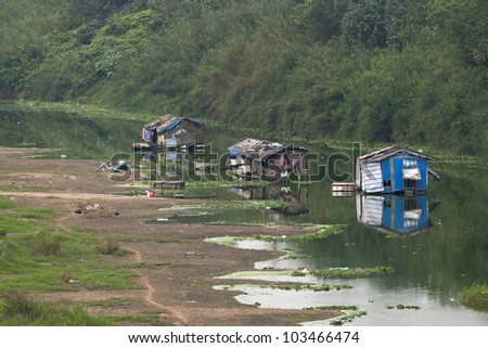 Dead arm of river houses a few boats used as poor living shelters.