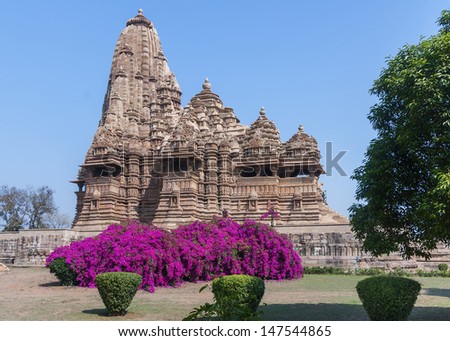 Hindu temple, built by Chandela Rajputs, at Western site in India\'s Khajuraho isolated against blue sky and park.