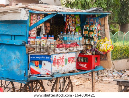 AGRA, INDIA - CIRCA FEBRUARY 2011: Street vendor sells basic grocery products in a typical small booth on wheels.