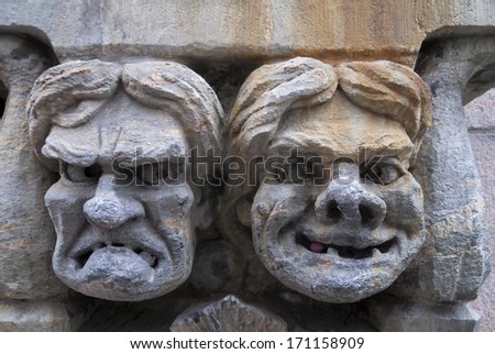 Helsinki, Finland - Circa September 2010: Fresco Of Angry And Happy Male\'S Face Set In Stone. Close Up Of Mural Statue In The Wall Of A Business In Downtown Helsinki. The Two Faces Look At Each Other.