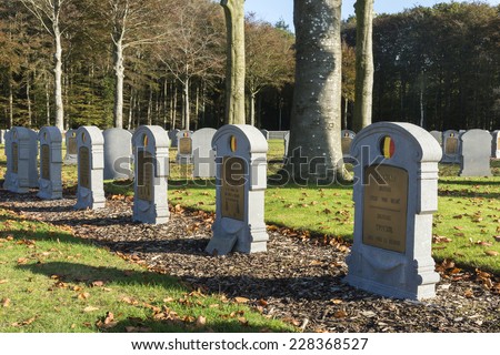 HOUTHULST, BELGIUM - OCTOBER 27, 2014: First tombstone for Unknown Soldier. Lines of tombstones under trees covered in fall colors for the soldiers who fell during the last major attack of the war.