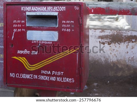 KUMBAKONAM, INDIA - OCTOBER 11, 2013: Official India Post red mail deposit box in the street.