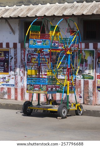 KUMBAKONAM, INDIA - OCTOBER 11, 2013: Small ferris wheel, aimed at little children, and only having four seats, stands in the street. Used at street fairs.