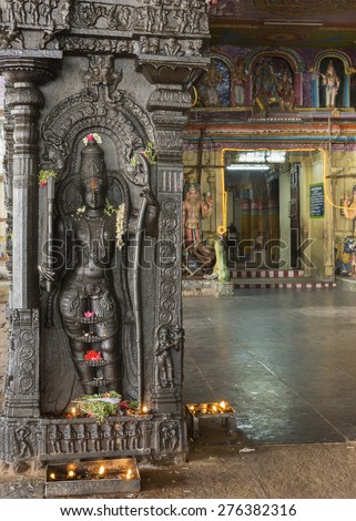KUMBAKONAM, INDIA - OCTOBER 12, 2013: Ramaswamy Vishnu Temple, open sided Mandapam. Rama avatar of Vishnu carved in pillar. Entrance to the inner sanctum in background. Flowers on the Rama statue.