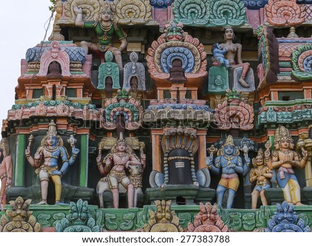 KUMBAKONAM, INDIA - OCTOBER 13, 2013: Kumbeswarar Temple Gopuram. Triumvirate of Hindu gods in the same photo: Shiva, Vishnu, Brahma. Krishna as baby breastfed by Putana.