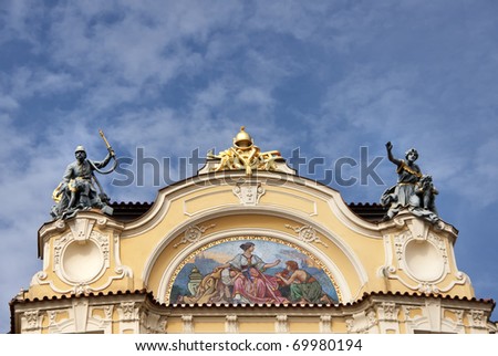Fresco and statues on top of mansion in Prague's Old Town square.