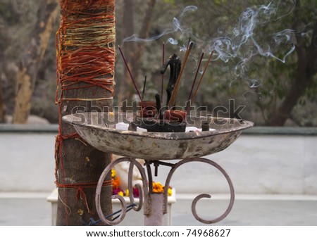 Landscape picture of burning incense outside Birla Hindu Temple in Delhi.