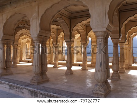 Gallery of rimmed pillars in light sunshine at Jaipur\'s Amber Fort.