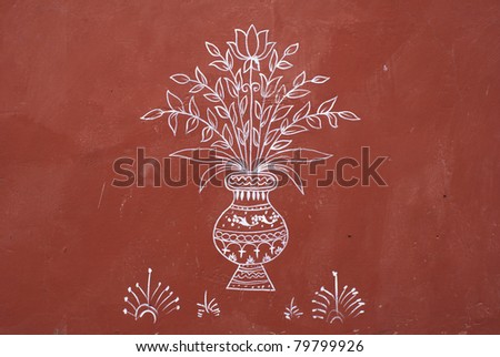 Simple white painting on red wall of vase with flowers at Jaipur\'s Jaigarh Fort. Naive mural of fine lines combining into a striking image.