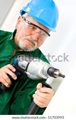 Construction worker holding the electric hand drill