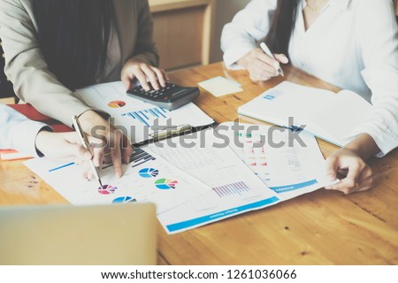 Asian business people meeting with new startup project pointing graph discussion and analysis data charts and graphs.Business finances and accounting concept